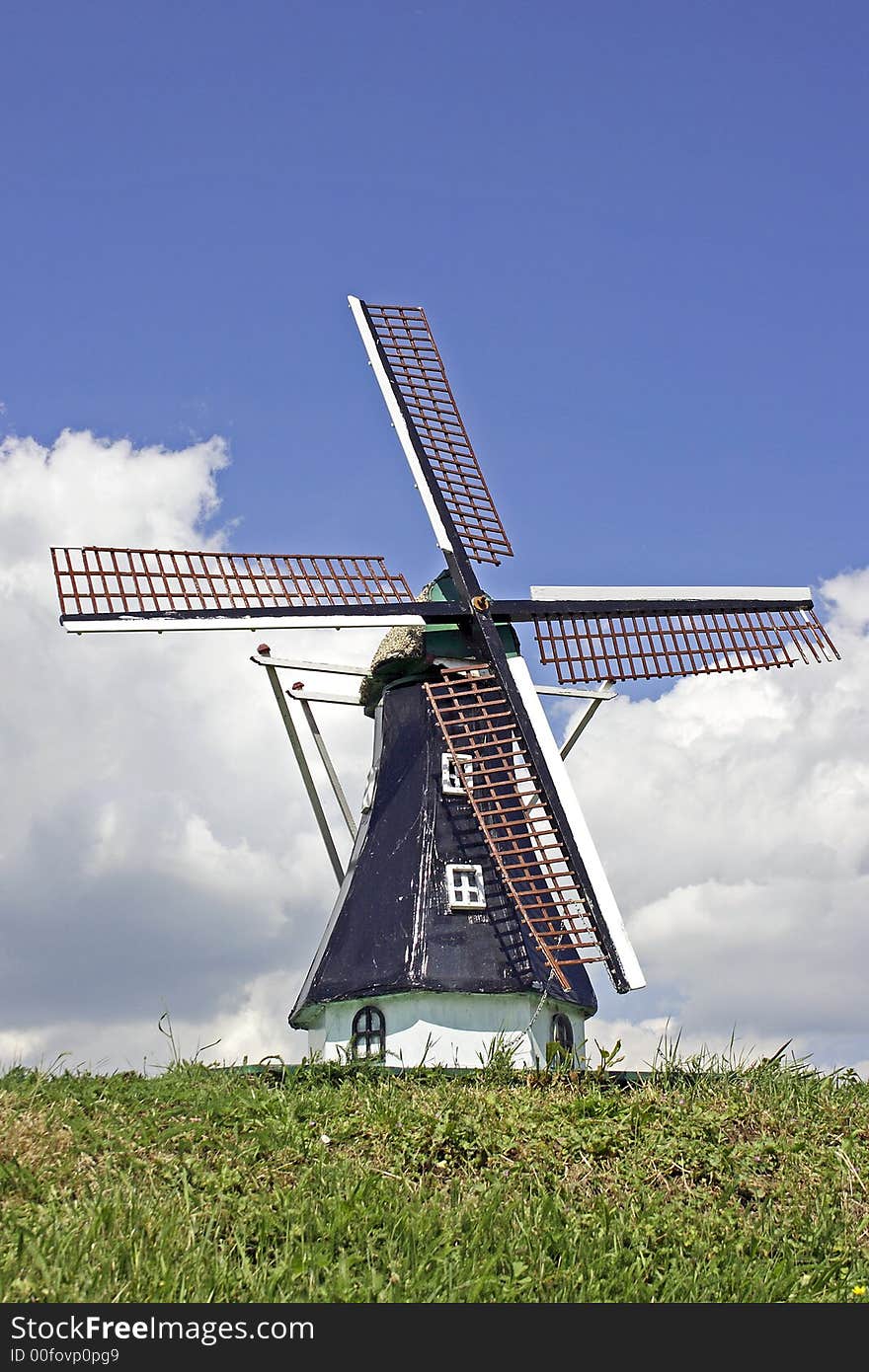 Old dutch windmill in the countryside in the Netherlands against a blue sky