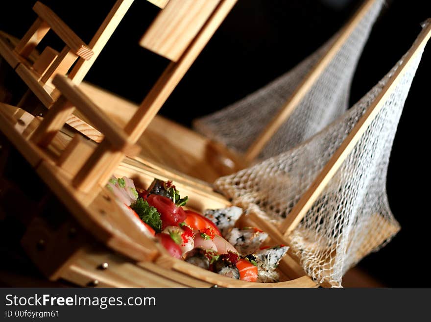 An assortment of sushi on a typical sushi boat used at Japanese restaurants. An assortment of sushi on a typical sushi boat used at Japanese restaurants