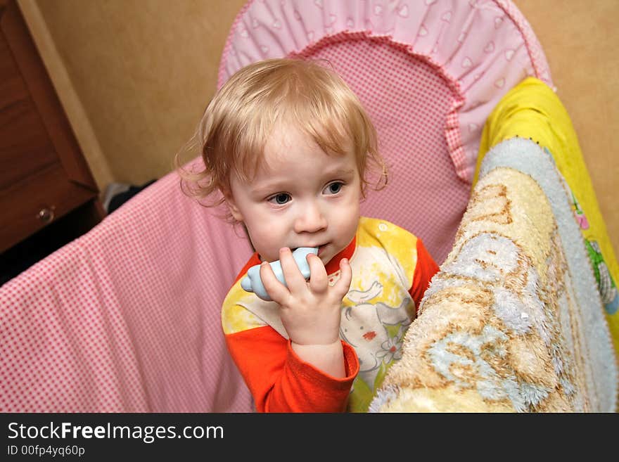 The boy in a cot plays with a toy. The boy in a cot plays with a toy