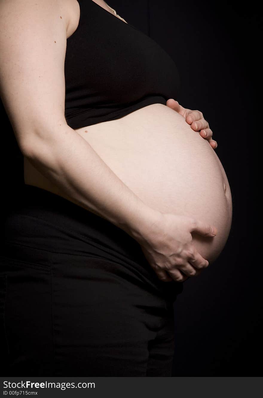 Side profile of a woman's pregnant belly. Side profile of a woman's pregnant belly