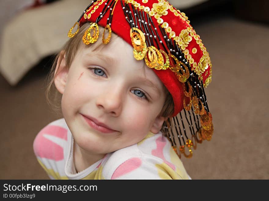 The girl in skullcap  poses at home