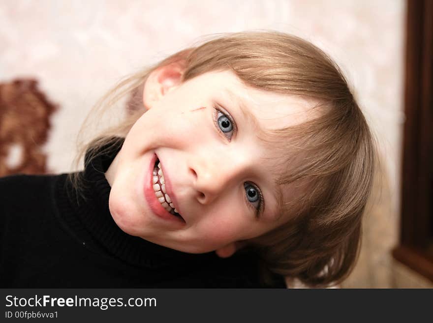 A smiling girl with blue eyes poses at home