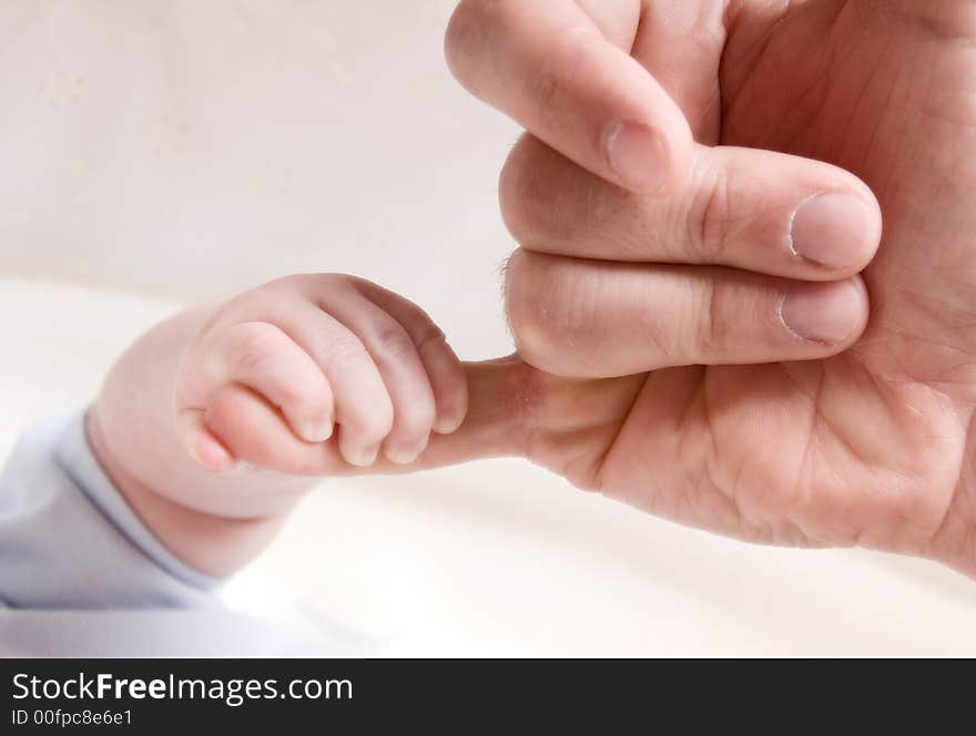 Small baby hand holding on to dad's finger. Small baby hand holding on to dad's finger