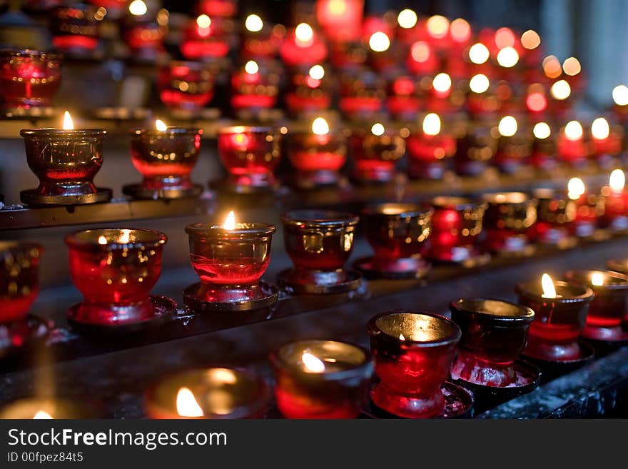 Many little candles in red glass in church. To remembrance. Very small DOF. Many little candles in red glass in church. To remembrance. Very small DOF.