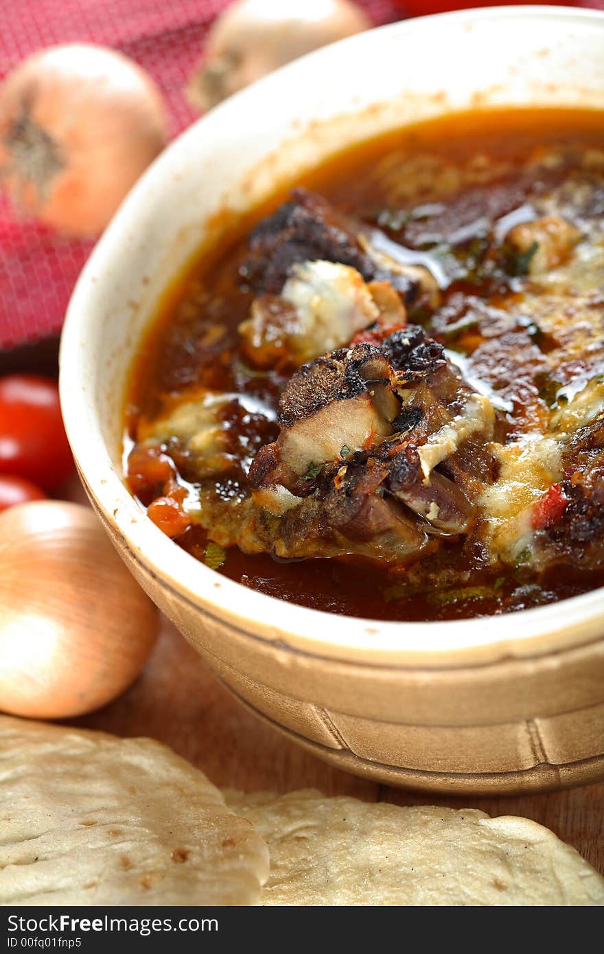 Beef stewed in tomatoes with onion and roll