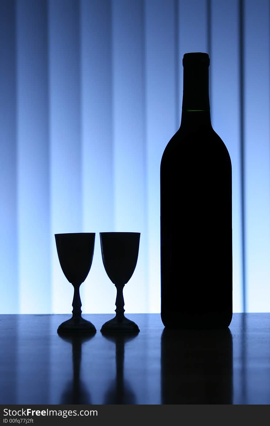 Wine bottle with two glasses, dramatic light, copy-space for text.