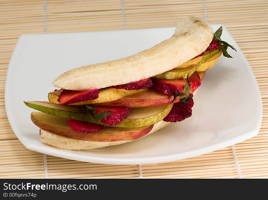 Mixed fruits looking like sandwich on white plate