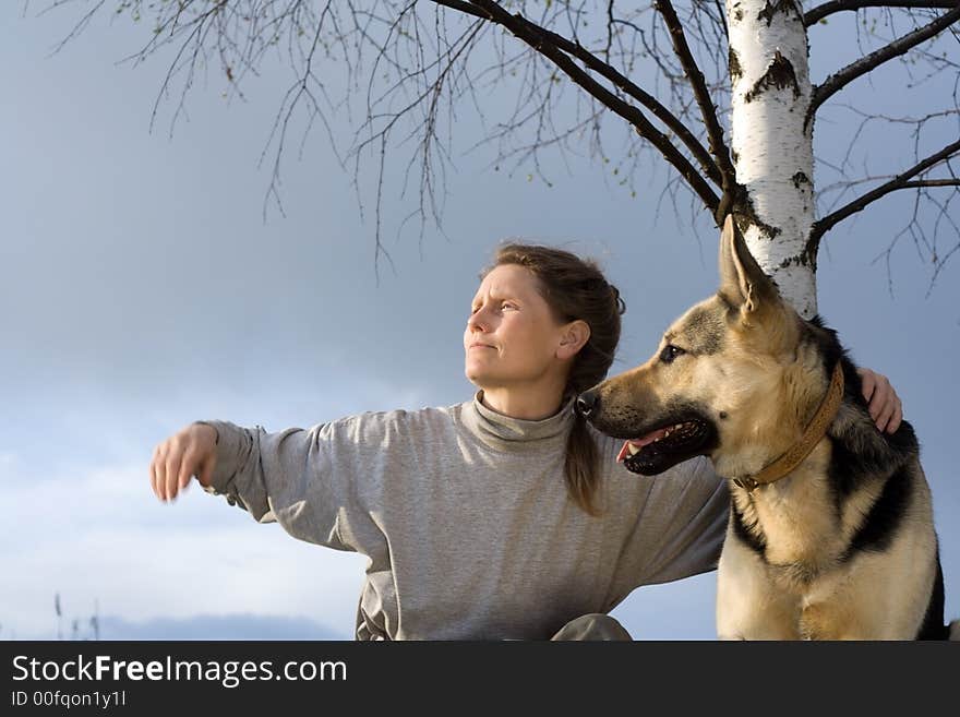 Woman communicate with alsatian dog under birch. Woman communicate with alsatian dog under birch