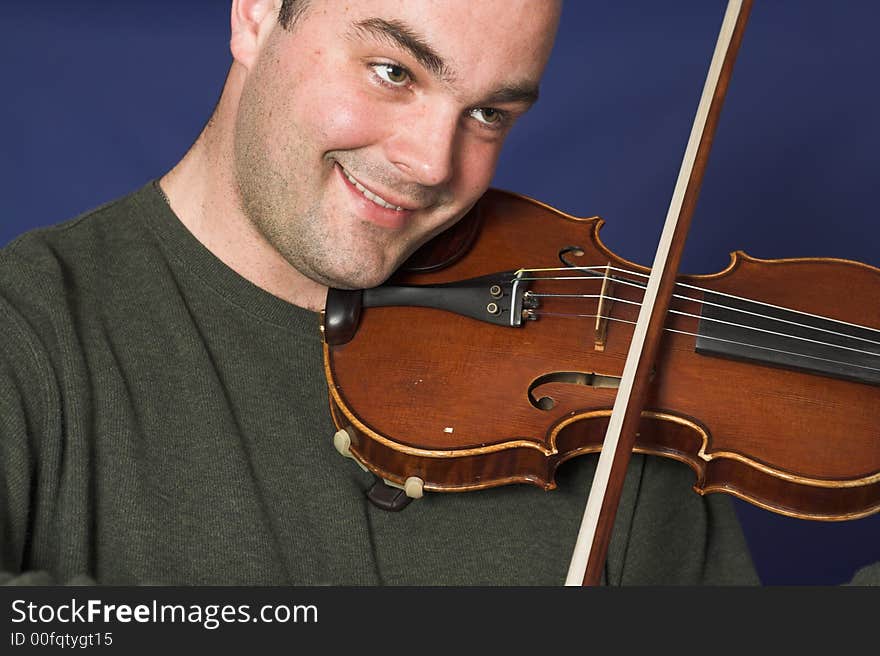 Portrait of man playing violon over blue background