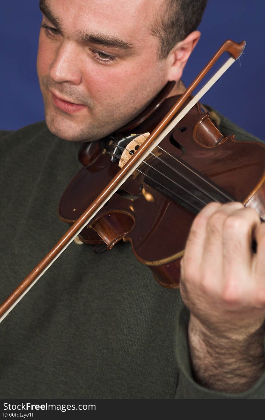 Portrait of man playing violon over blue background