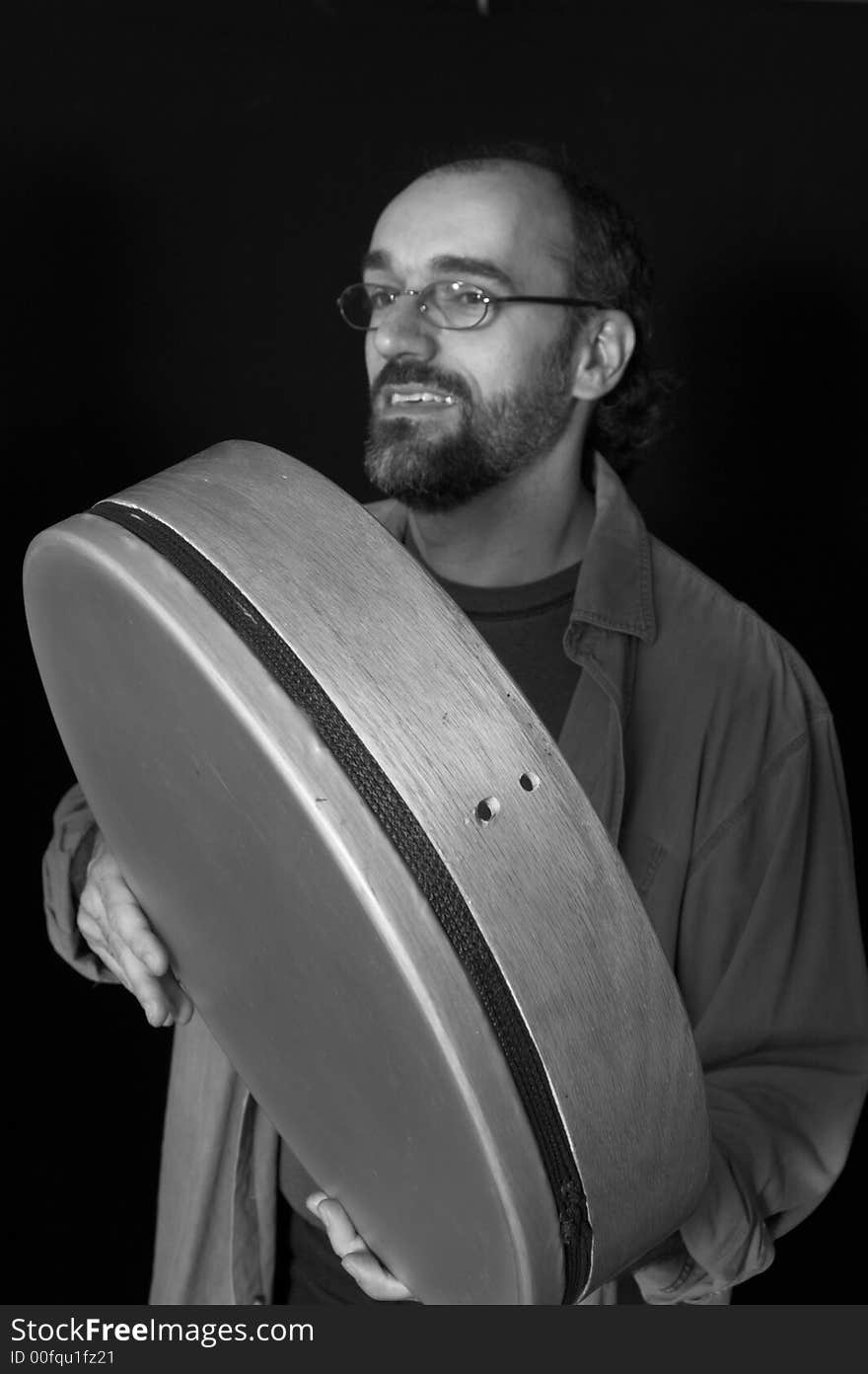 Portrait of man playing drum over black background