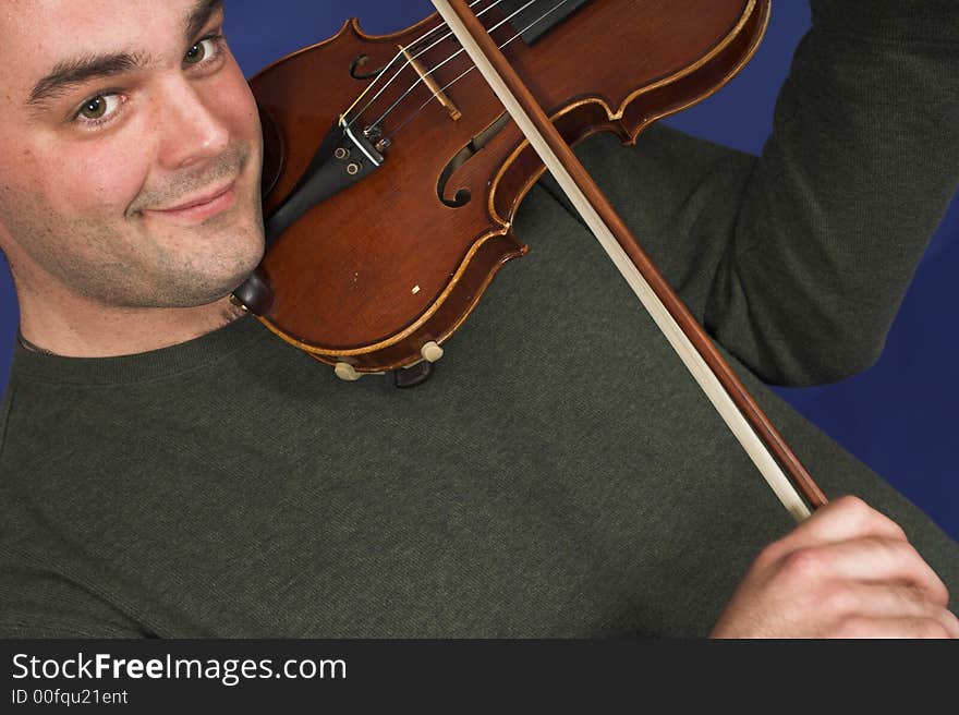 Portrait of man playing violon over blue background