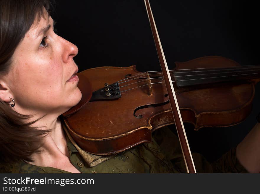 Mid-age woman playing violon over black background