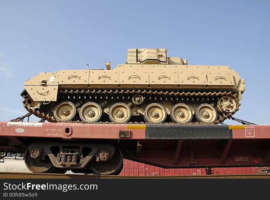 A military tank being shipped by rail. A military tank being shipped by rail