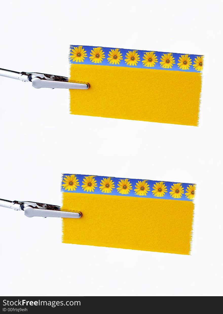 Two yellow notice-cards on metal-clip. Two yellow notice-cards on metal-clip