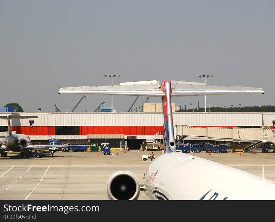 Large airline jets waiting at gates of a busy airport. Large airline jets waiting at gates of a busy airport