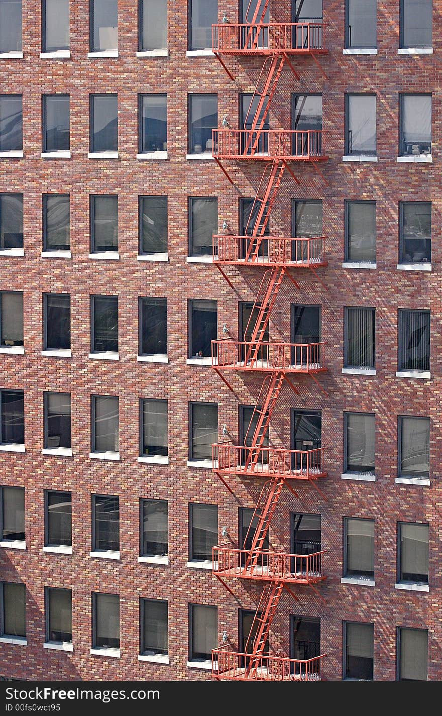 A red fire escape on an old red brick building