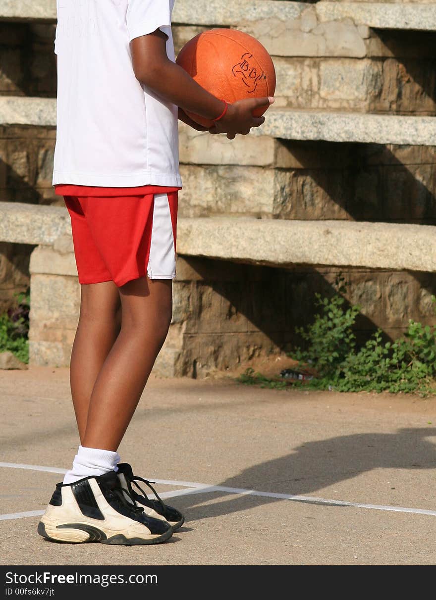 A young boy (10-12) holding a basketball. A young boy (10-12) holding a basketball.