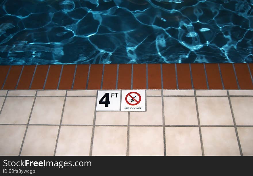 Photo of a no diving symbol next to a pool