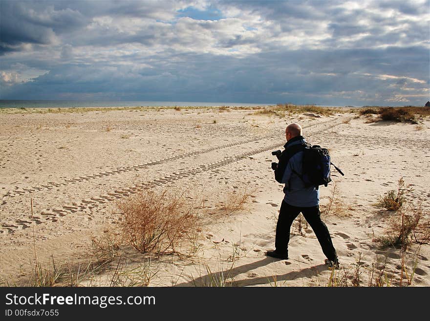 Walk on fresh air, productive leisure, a beautiful decline on seacoast Sandy seacoast on a decline, the phototourist in dynamical movement. Walk on fresh air, productive leisure, a beautiful decline on seacoast Sandy seacoast on a decline, the phototourist in dynamical movement