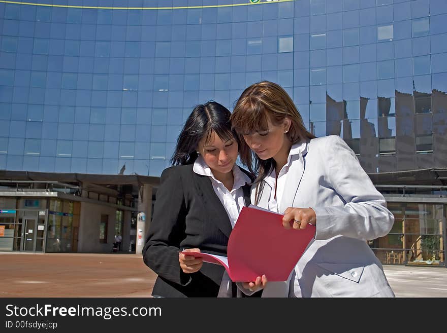 Businesswoman downtown reading a file. Businesswoman downtown reading a file