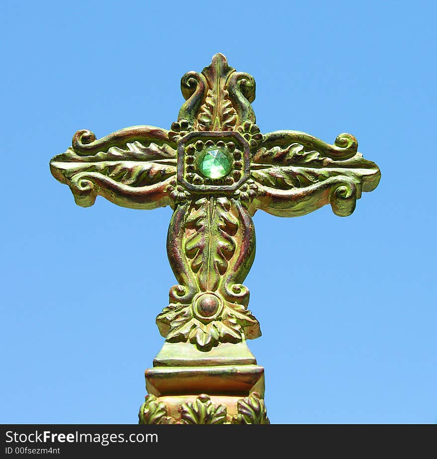 An antique cross with a blue sky in the background. An antique cross with a blue sky in the background.