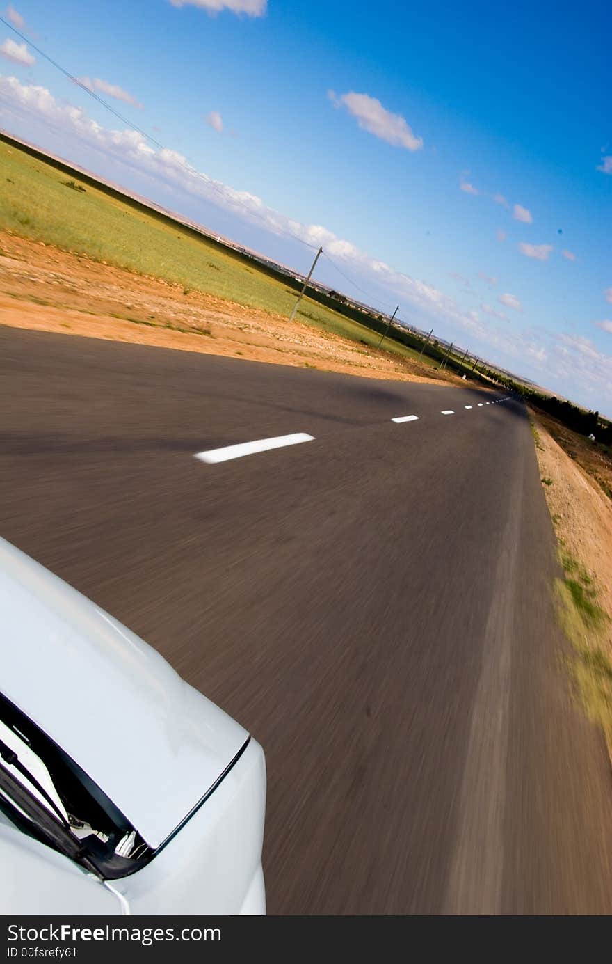 Car moving fast through the desertic landscape of Morocco. The blur highlights the motion effect. Car moving fast through the desertic landscape of Morocco. The blur highlights the motion effect