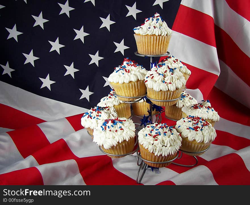 Dozen cupcakes arranged on a dessert tier with the USA flag as background. Dozen cupcakes arranged on a dessert tier with the USA flag as background