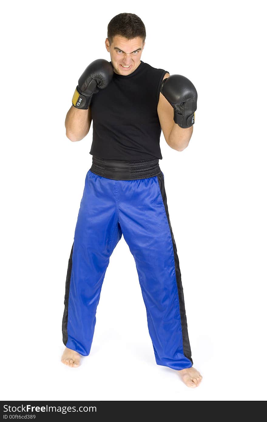 Angry young man in black boxing gloves, isolated on white in studio looking at camera. Whole body, front side. Angry young man in black boxing gloves, isolated on white in studio looking at camera. Whole body, front side.