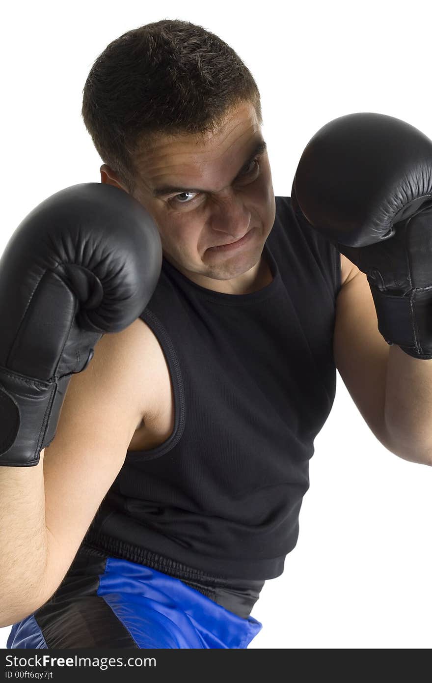 Angry young man in black boxing gloves with shady face, looking at camera. Isolated on white in studio. Angry young man in black boxing gloves with shady face, looking at camera. Isolated on white in studio.