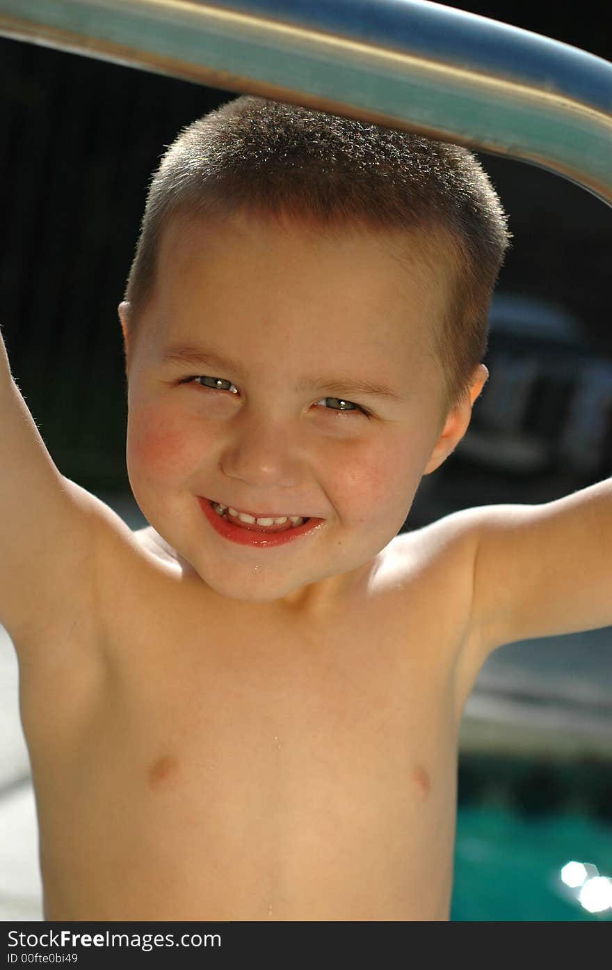 Boy standing in the pool, learning how to swim at an early age