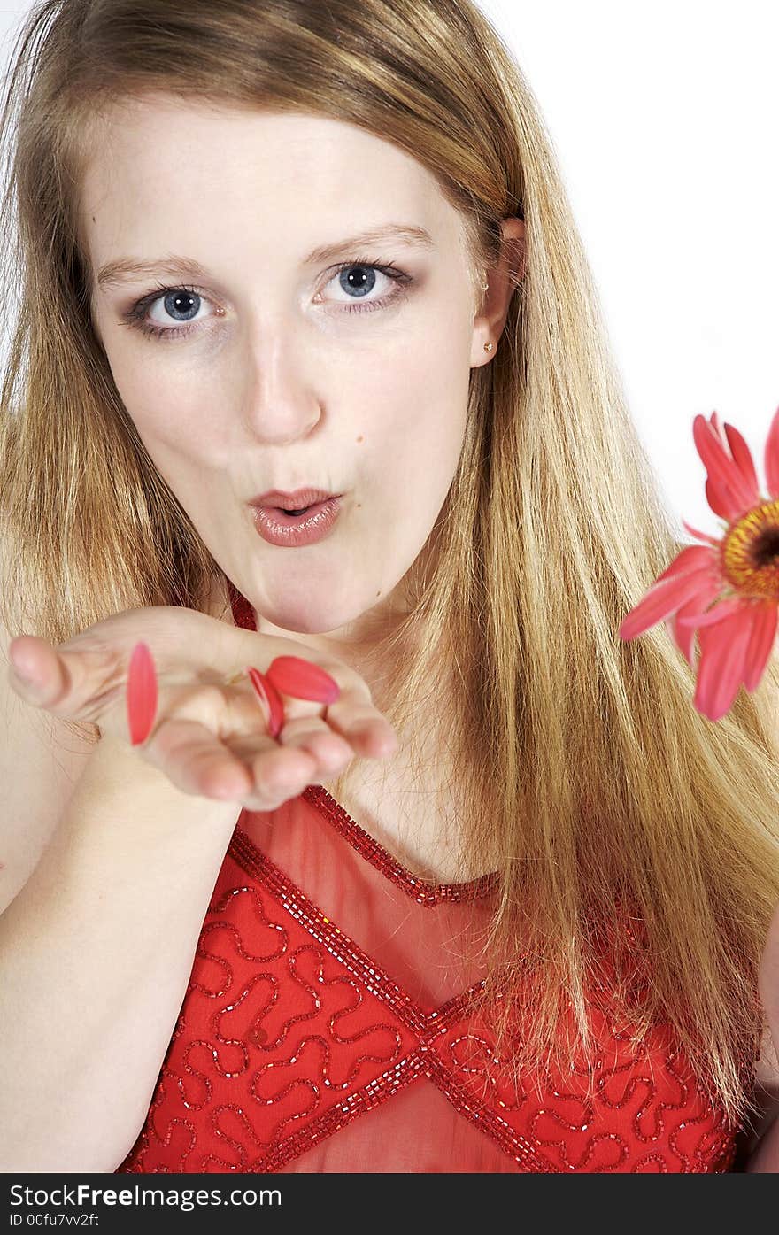 Attractive blond blowing petals from a daisy. Attractive blond blowing petals from a daisy