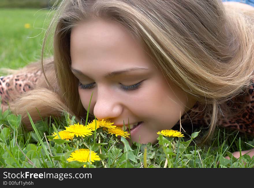 Pretty girl smells dandelion