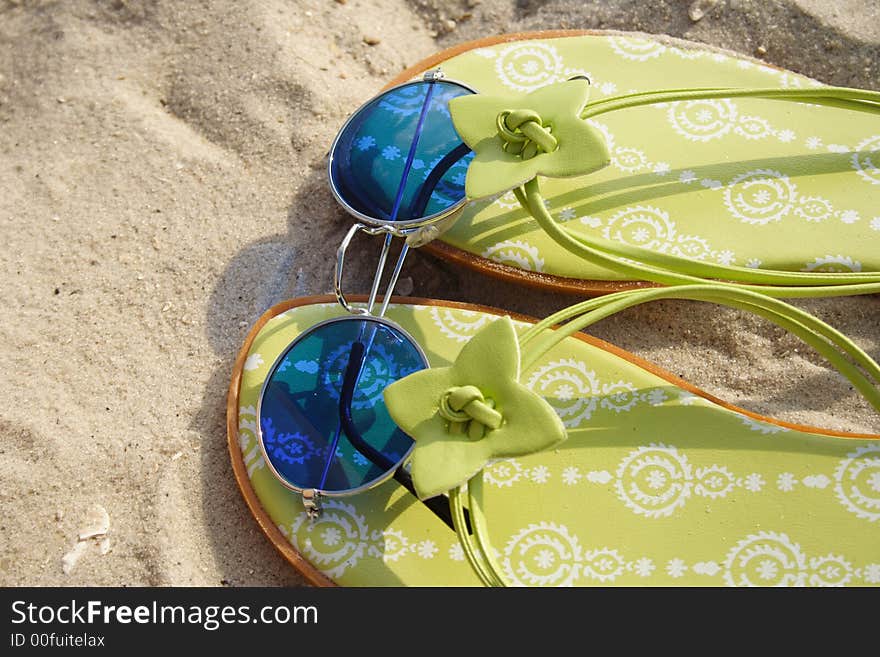 Close up of sandals and blue glasses. Close up of sandals and blue glasses