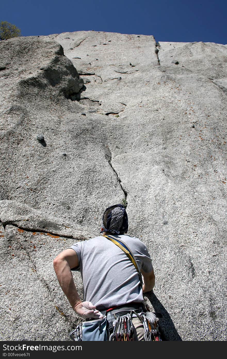 A man getting started on a rock climb. A man getting started on a rock climb