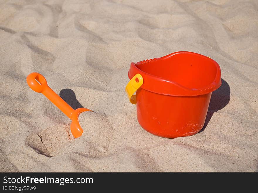 Orange toy shovel and red bucket. Orange toy shovel and red bucket