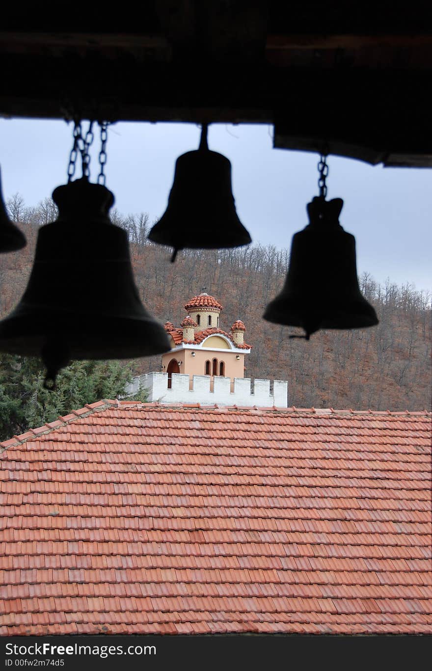 View of a small monastery through a couple of bells from St Anargiroi monastery in Greece. View of a small monastery through a couple of bells from St Anargiroi monastery in Greece