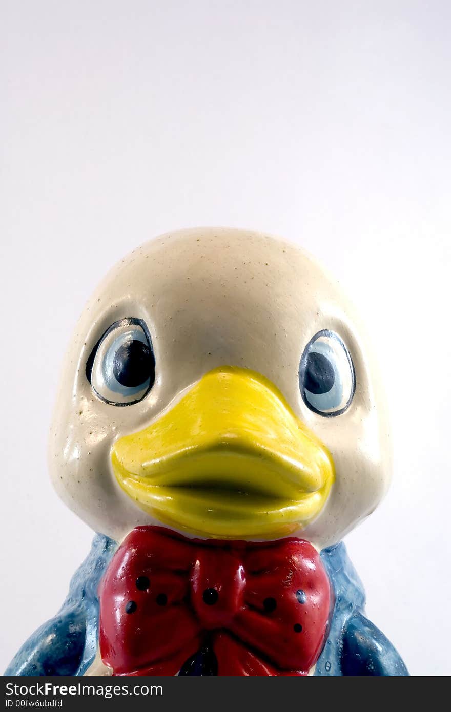 Closeup of funny ceramic duck piggy bank isolated on white background.