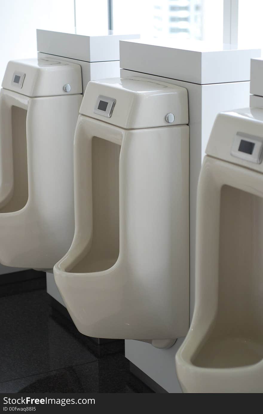 3 three urinals in an office toilet