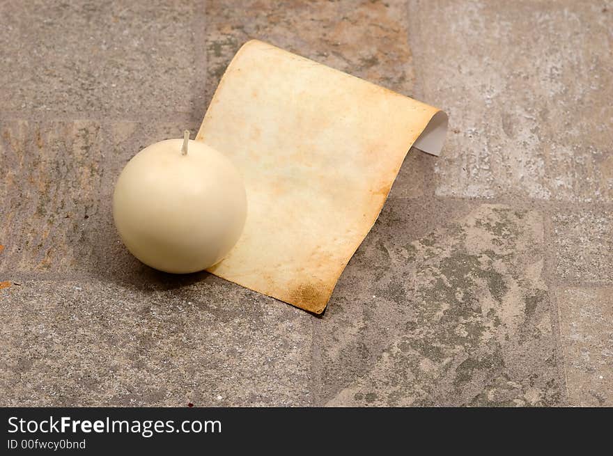 Very old paper with a candle  in a stone ( very textured stone)