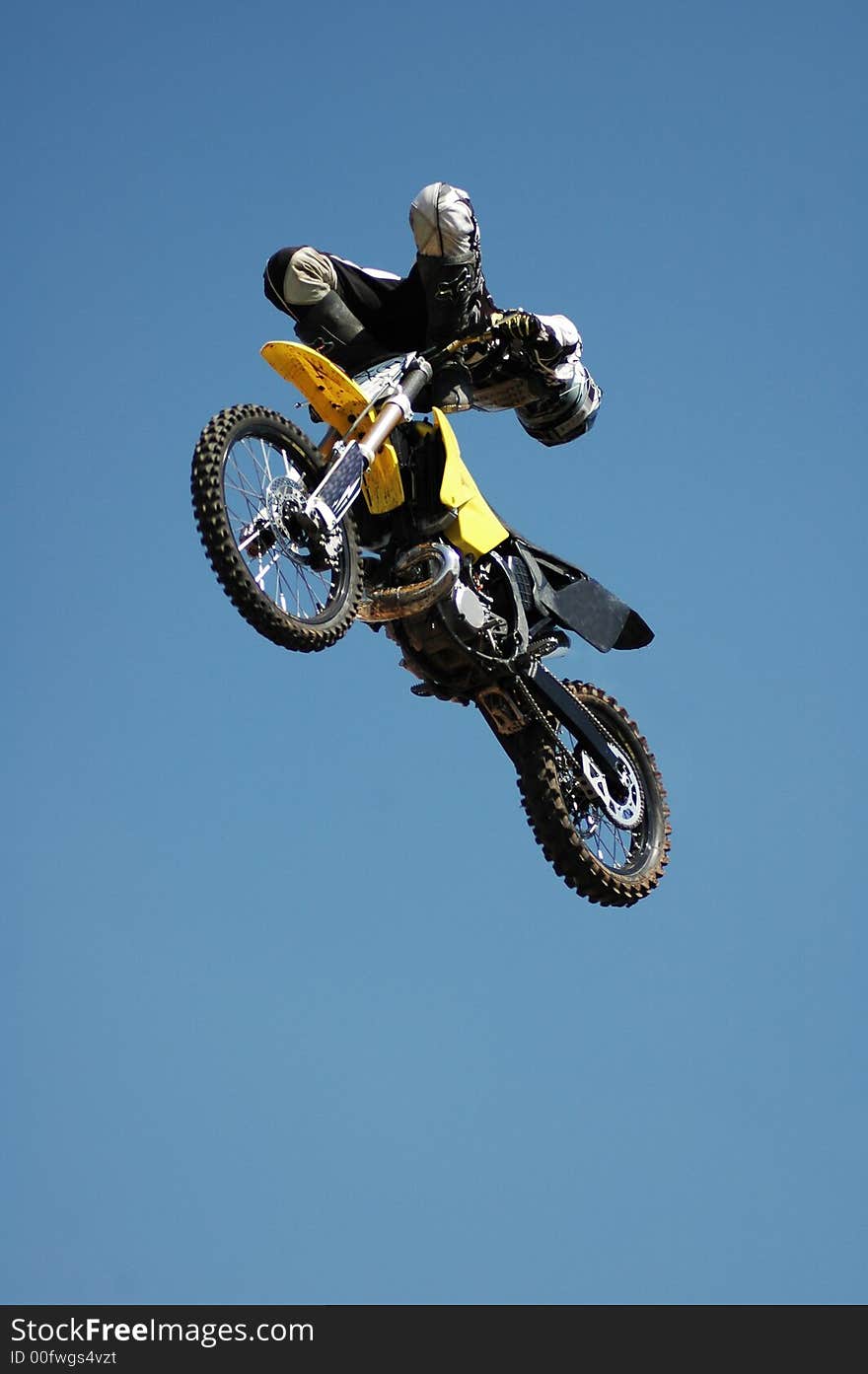 A stunt biker high up in the air.  All logos and trademarks removed digitally.