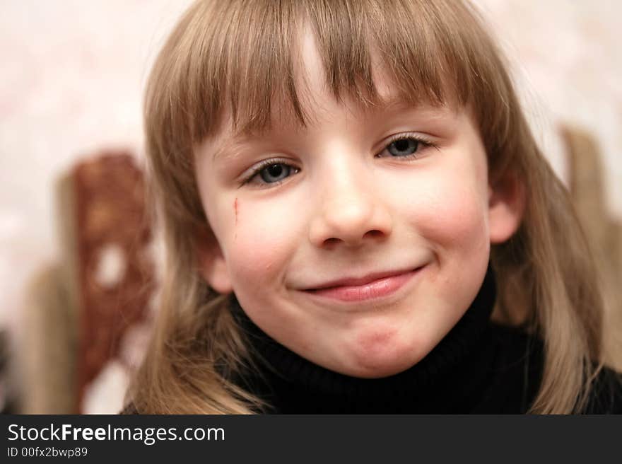 Cheerful girl with blue eyes poses at home