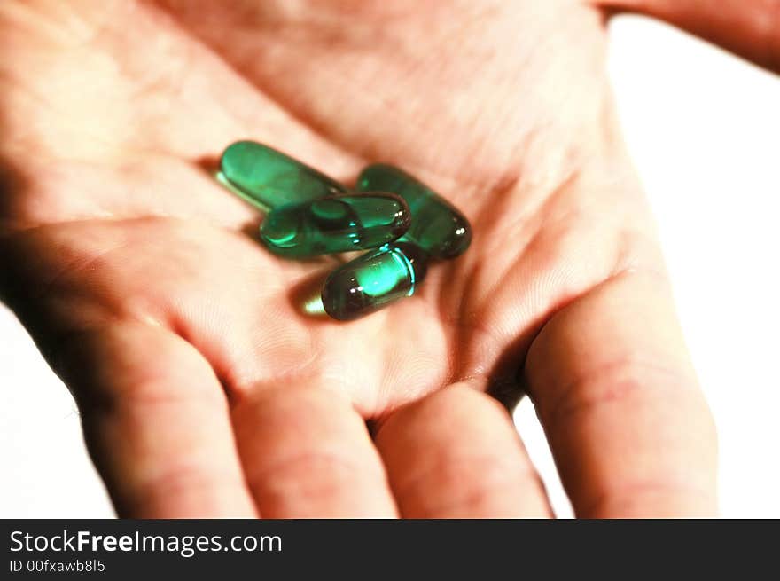 Close up of a hand holding some blue pills