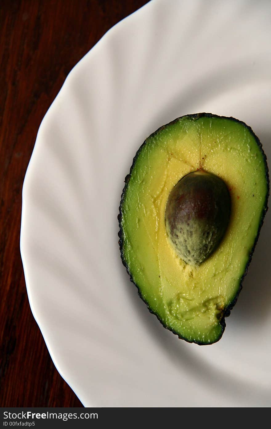 Half of avocado on the white plate