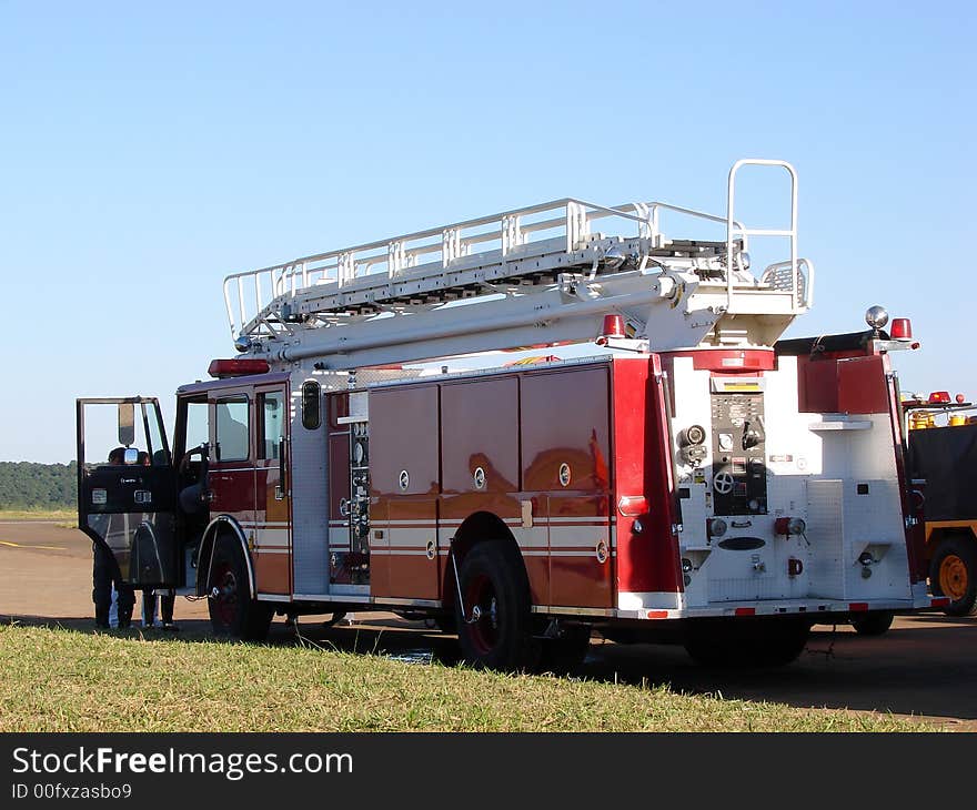 A red fire truck parked in a field.