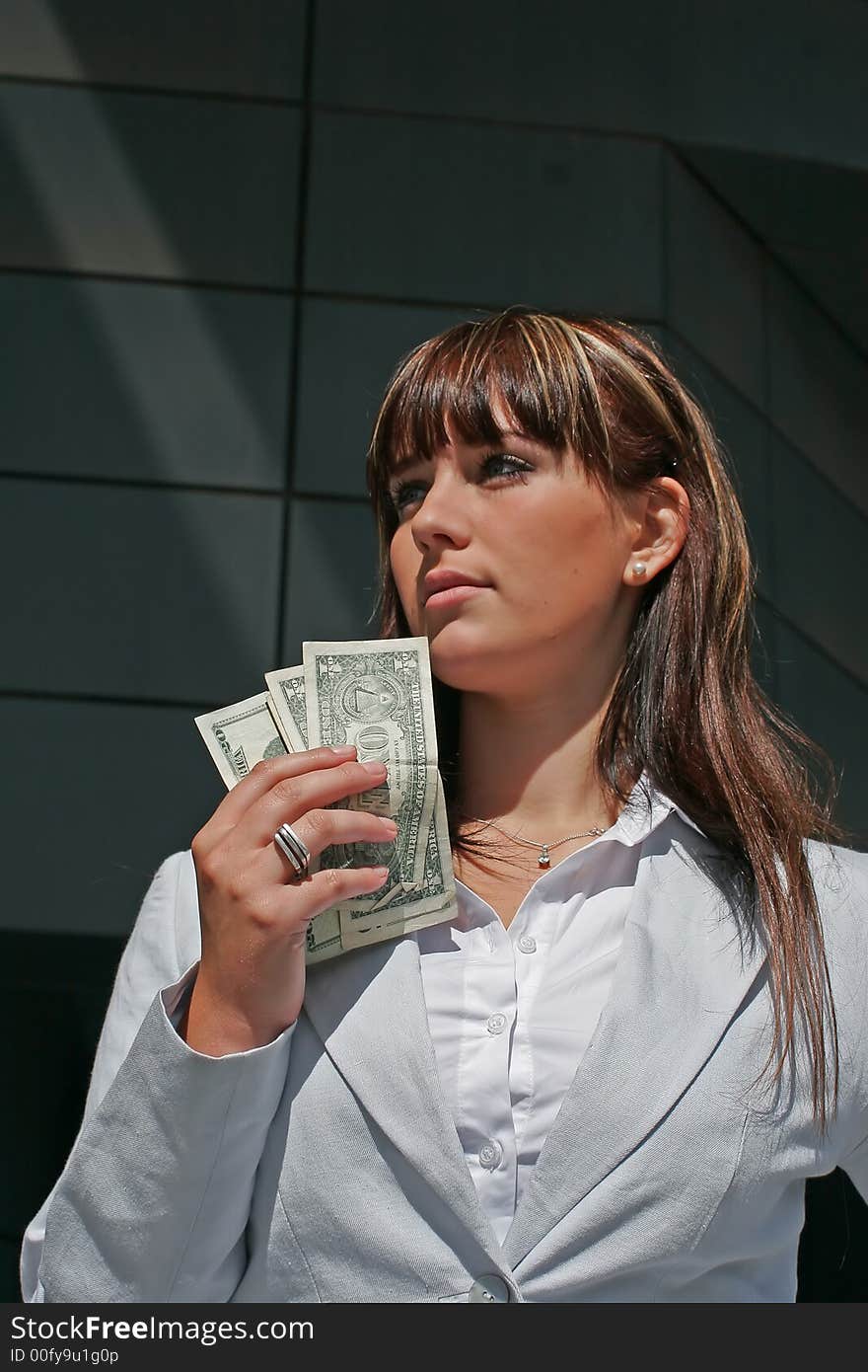 A portrait of a woman downtown with dollars in a hand. A portrait of a woman downtown with dollars in a hand