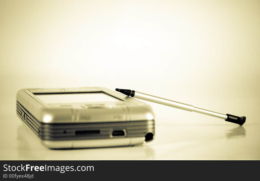 Modern vintage toned  Pocket PC with pen (focus on pen, vignette effect )