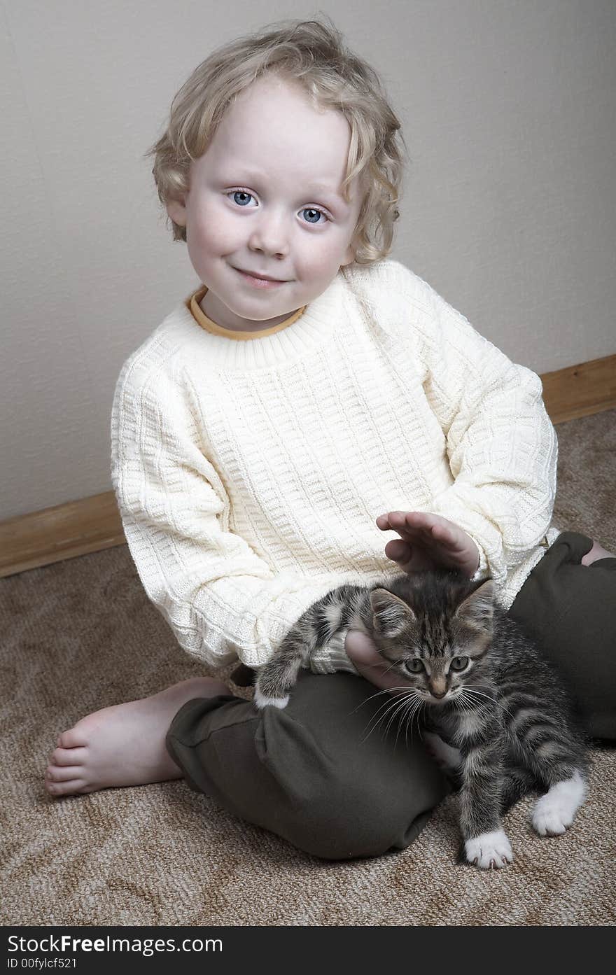 Little smiling blond adorable boy and kitten playing at home. Little smiling blond adorable boy and kitten playing at home