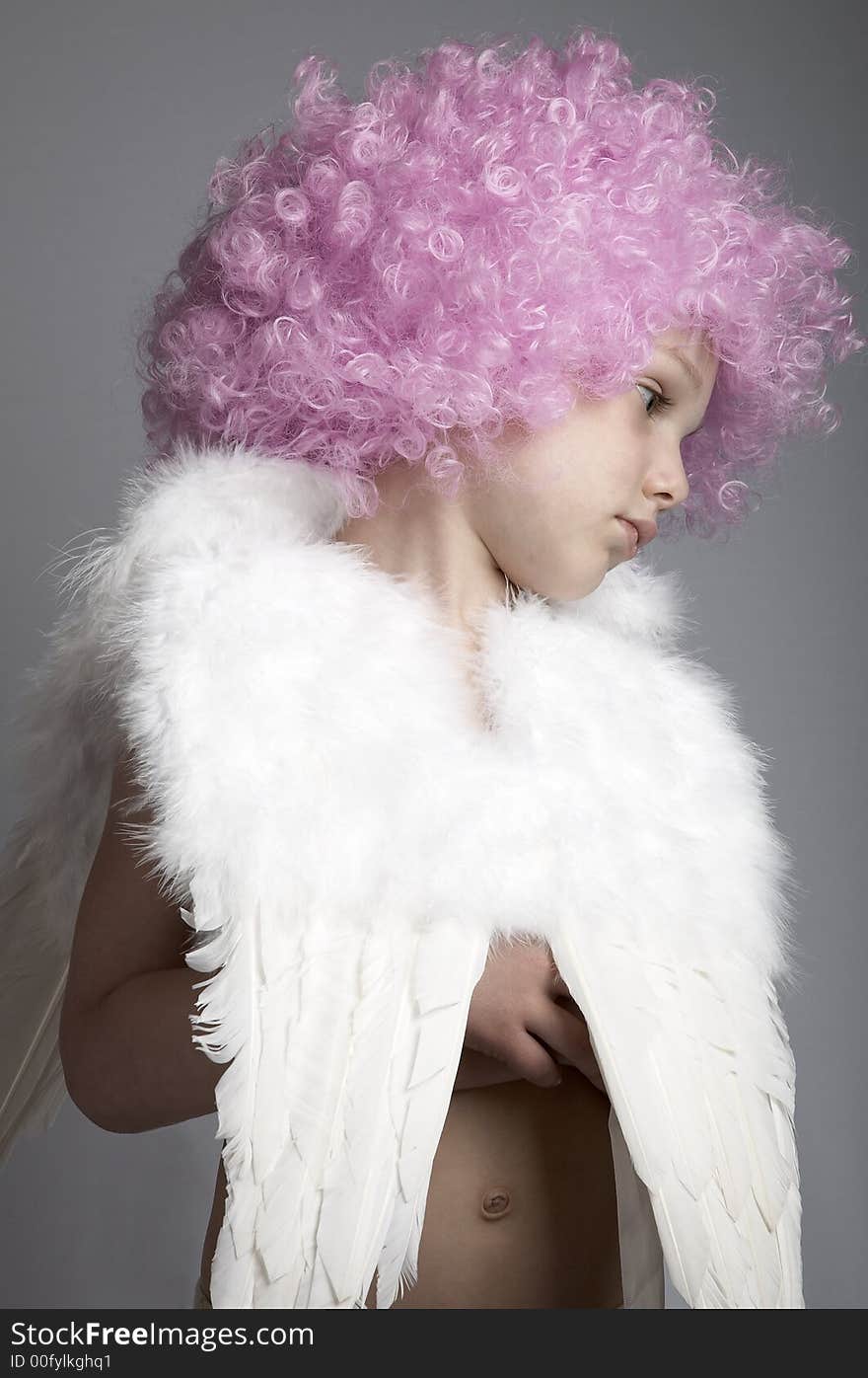 Little boy in pink wig and angel wings on plain background. Little boy in pink wig and angel wings on plain background