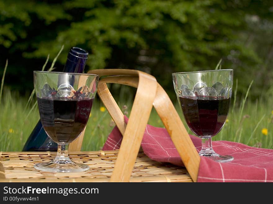 Basket of picnic in grass posed on a tablecloth